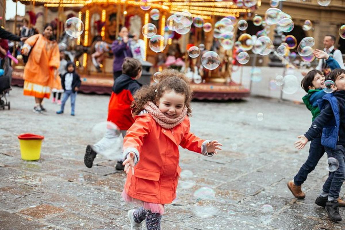 a little girl playing with bubbles in front of a carousel