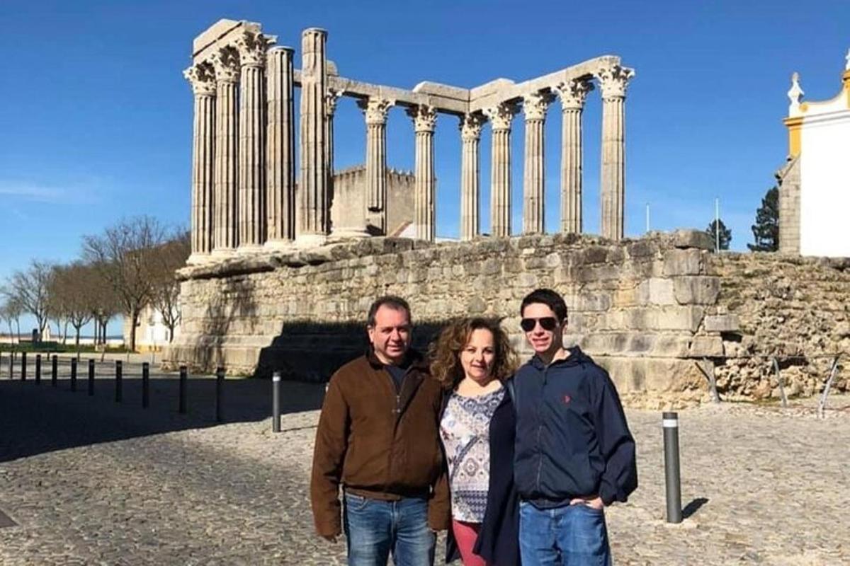 Un grupo de tres personas de pie frente a un templo.