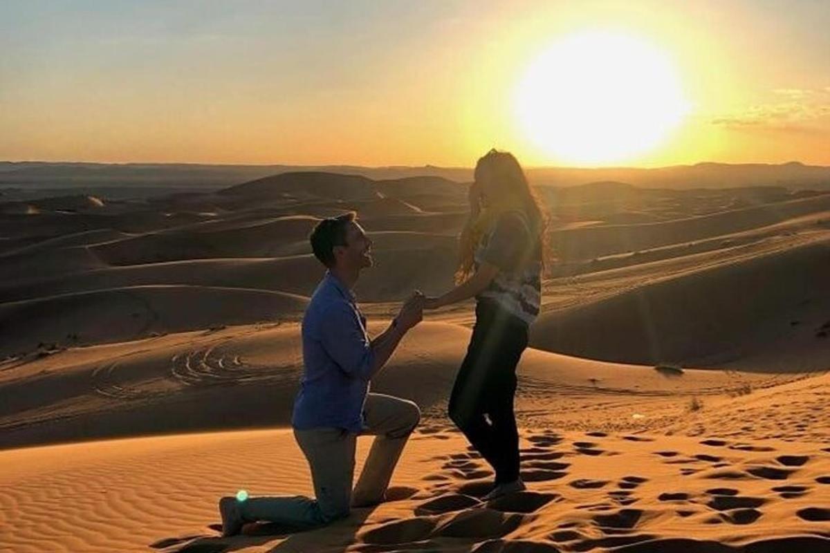 ein Mann und eine Frau in der Wüste bei Sonnenuntergang