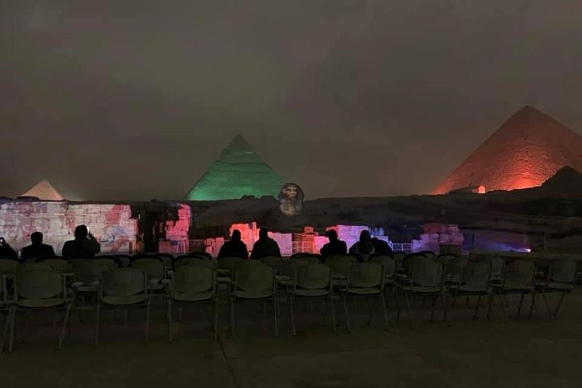 a group of people sitting in chairs in front of pyramids