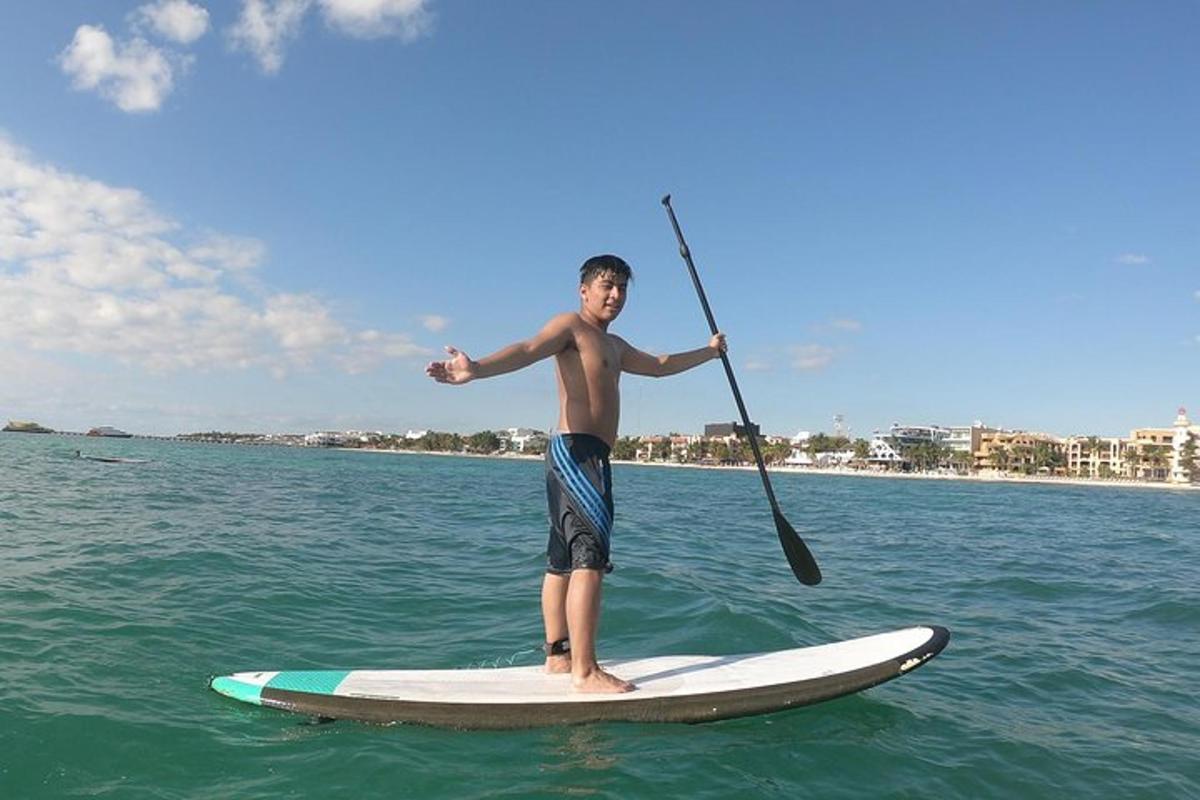 a man holding a paddle on a surfboard in the water