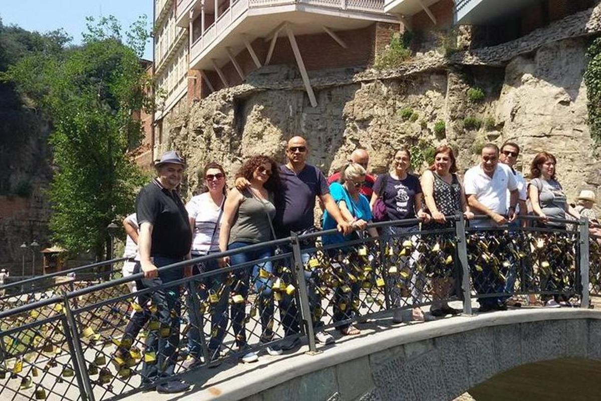 un gruppo di persone in piedi su un ponte