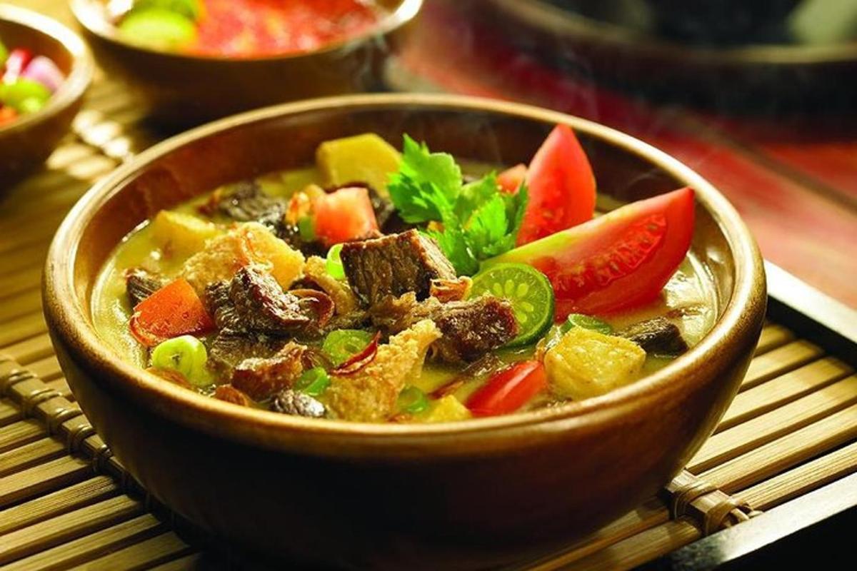 un bol de sopa amb carn i verdures a la taula