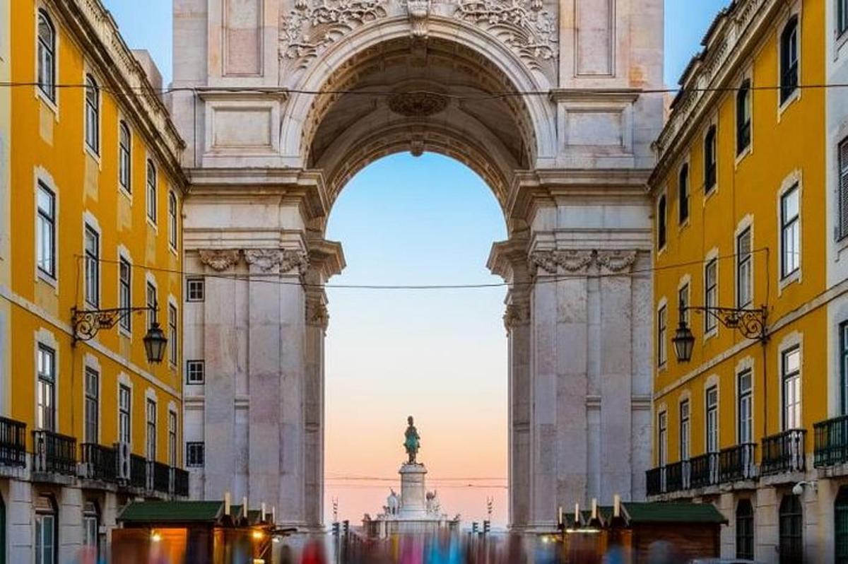 um arco com uma estátua no meio de dois edifícios