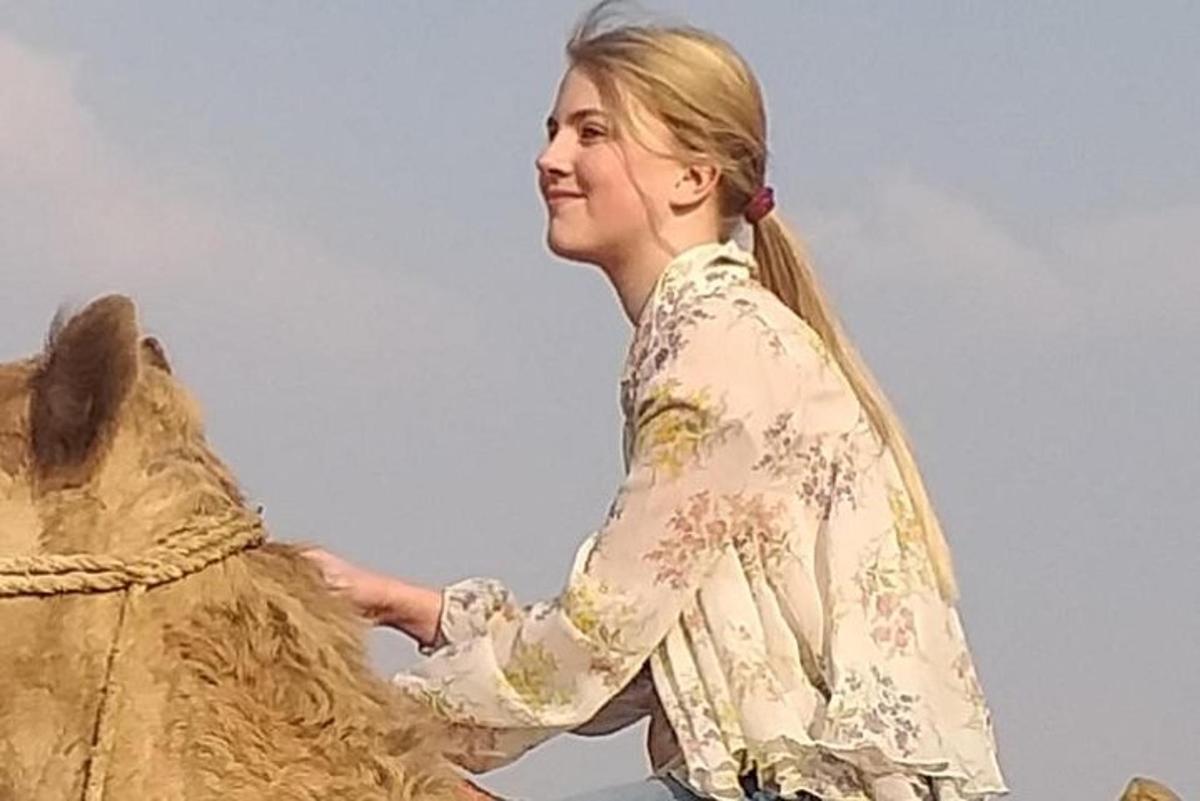 žena stojí vedle sochy
