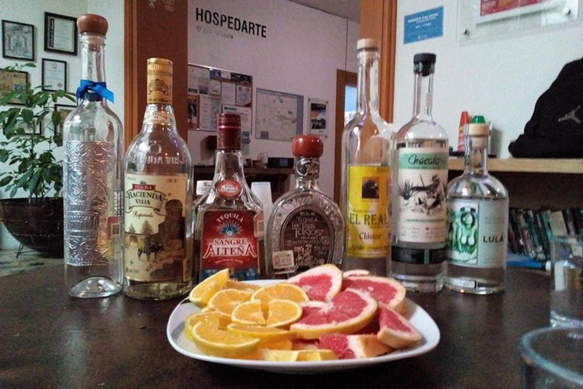krožnik sadja na mizi s steklenicami alkohola