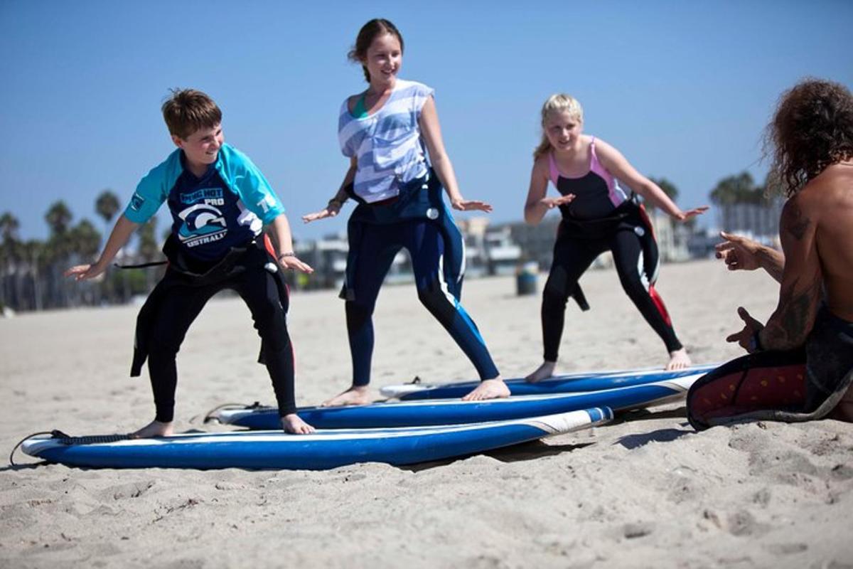 un gruppo di bambini in piedi sulle tavole da surf sulla spiaggia