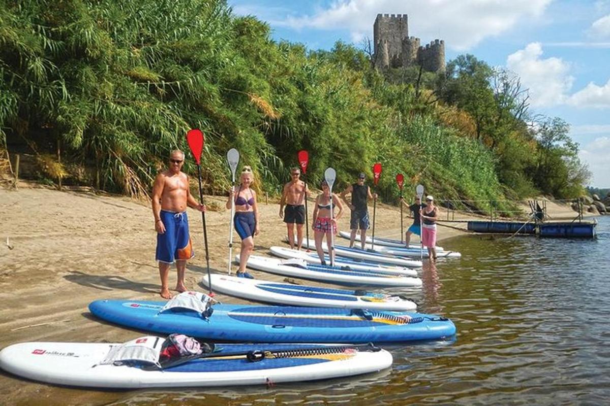 un gruppo di persone in piedi nell'acqua accanto alle tavole da surf