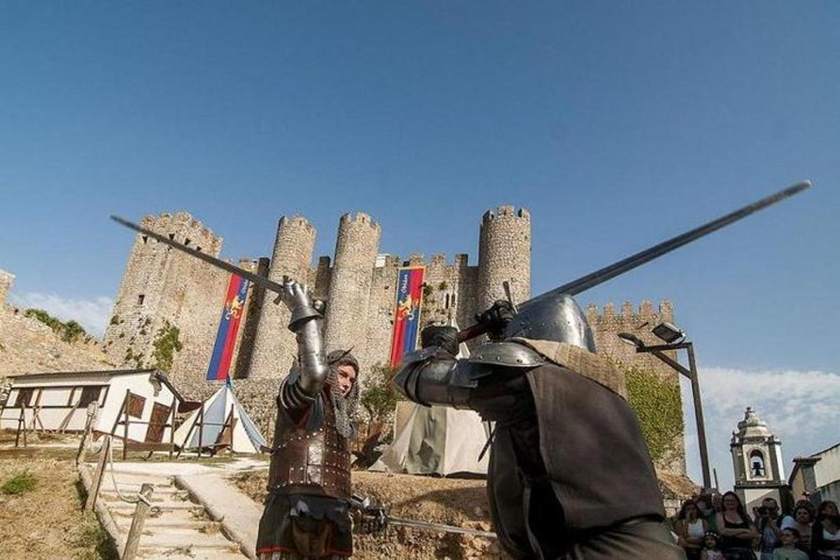 una donna in armatura in piedi davanti a un castello