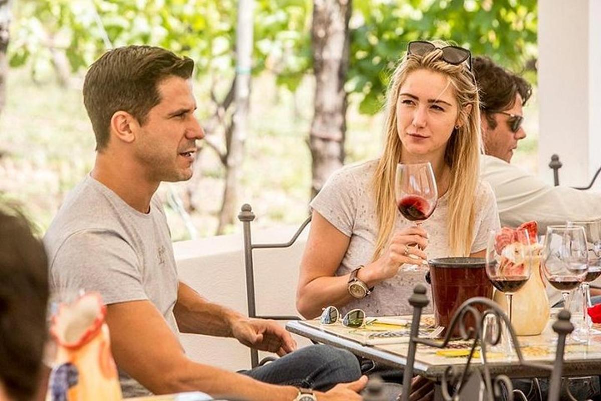 muž a žena sedící u stolu se sklenkou vína