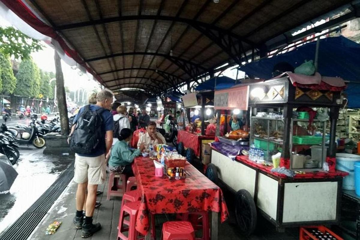 skupina lidí sedících u stolů ve stánku s občerstvením