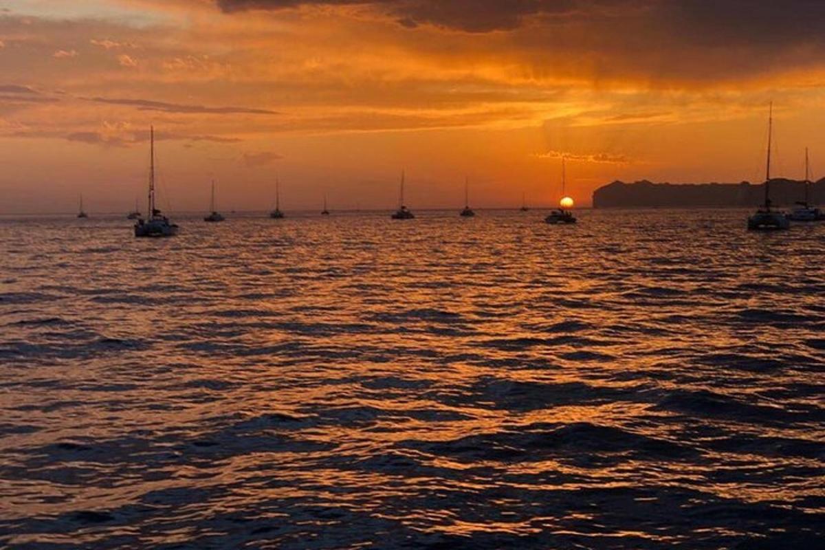 un gruppo di barche in acqua al tramonto