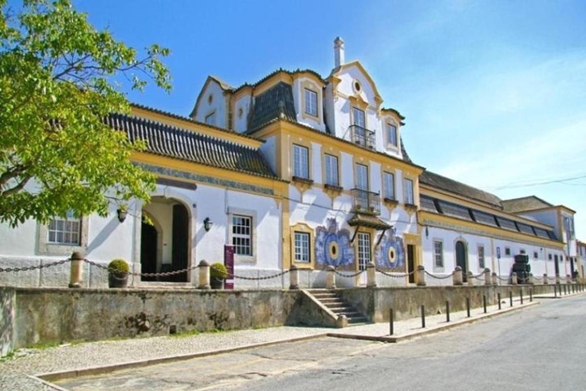 un grande edificio giallo e bianco con una recinzione