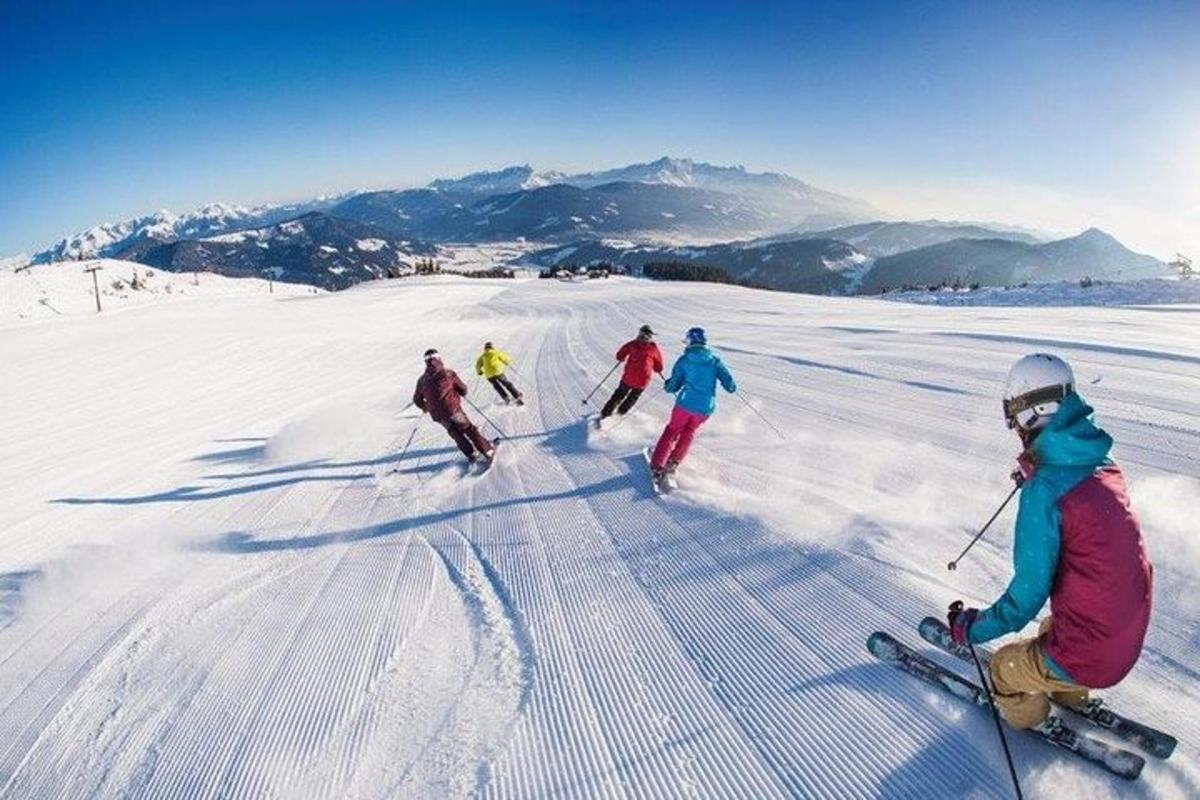un grup de oameni schiază pe o pantă acoperită de zăpadă