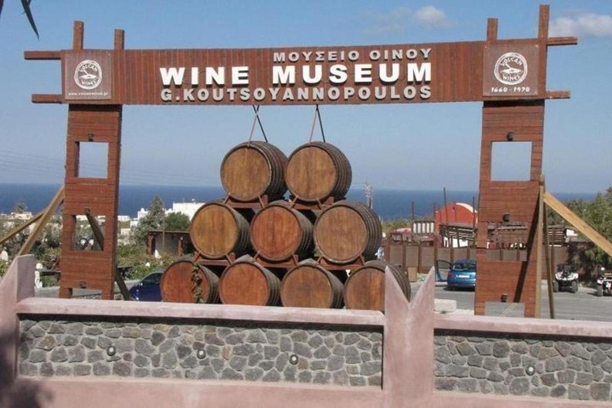 Un montón de barriles de vino apilados encima de un cartel.