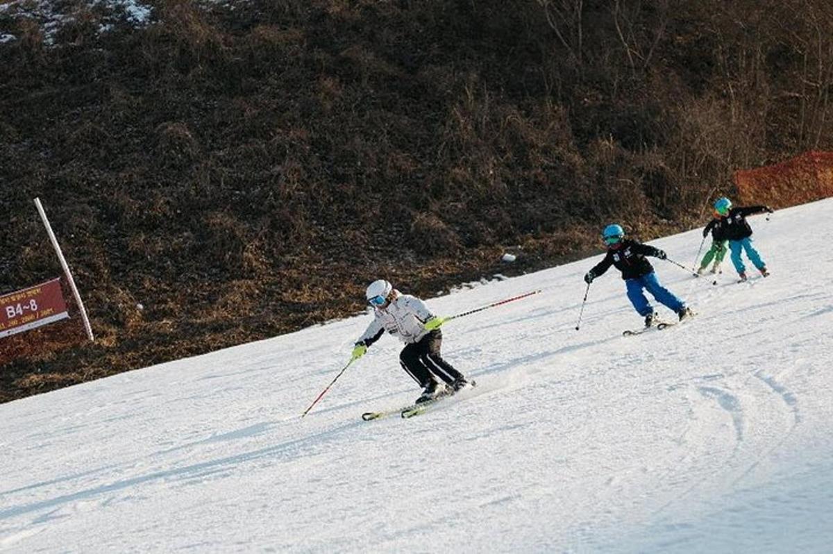 three people are skiing down a snow covered slope