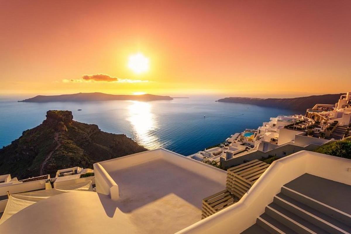 un tramonto sull'oceano con edifici bianchi