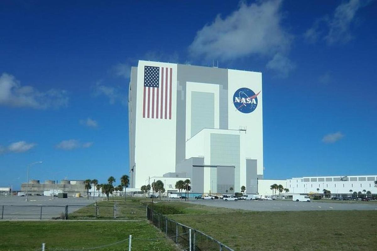 Un gran edificio con una bandera estadounidense y un Nissan.