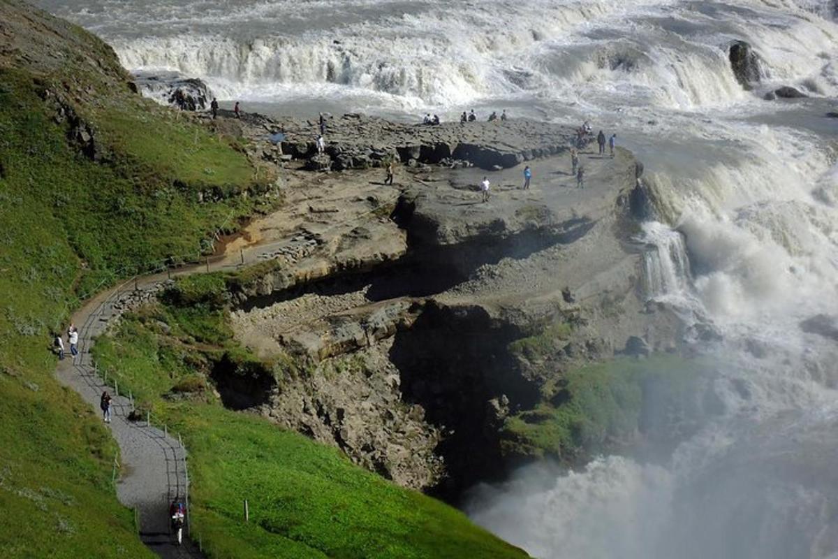 a group of people standing on the edge of a waterfall