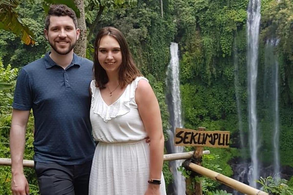 un uomo e una donna in piedi davanti a una cascata