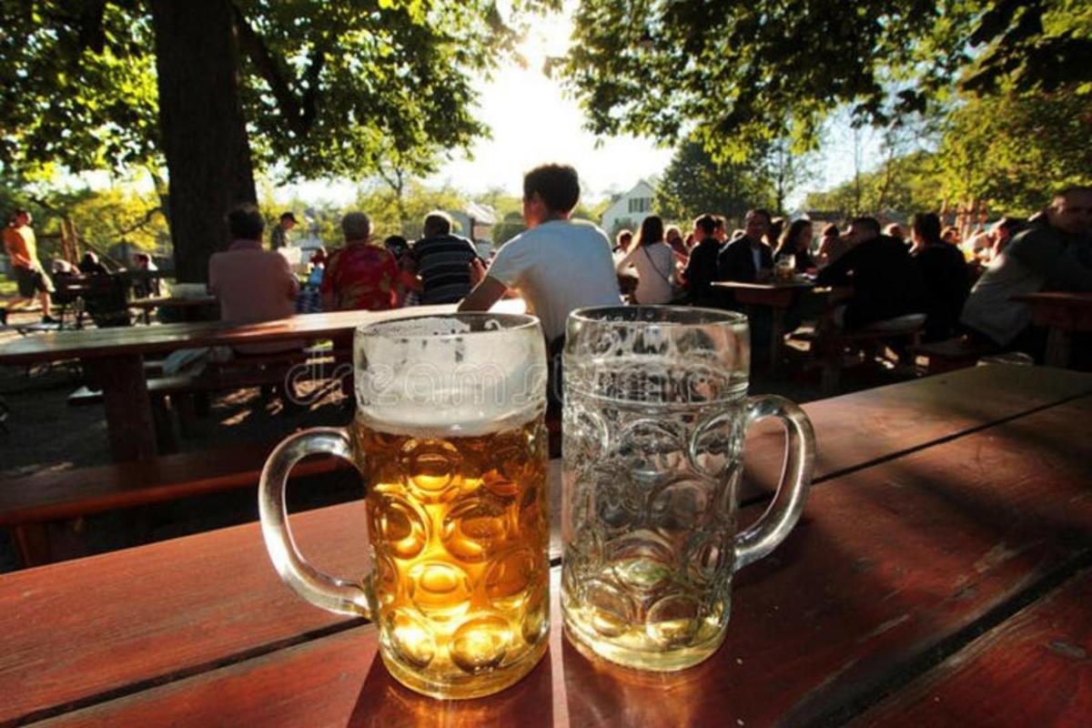 two glasses of beer sitting on a wooden table