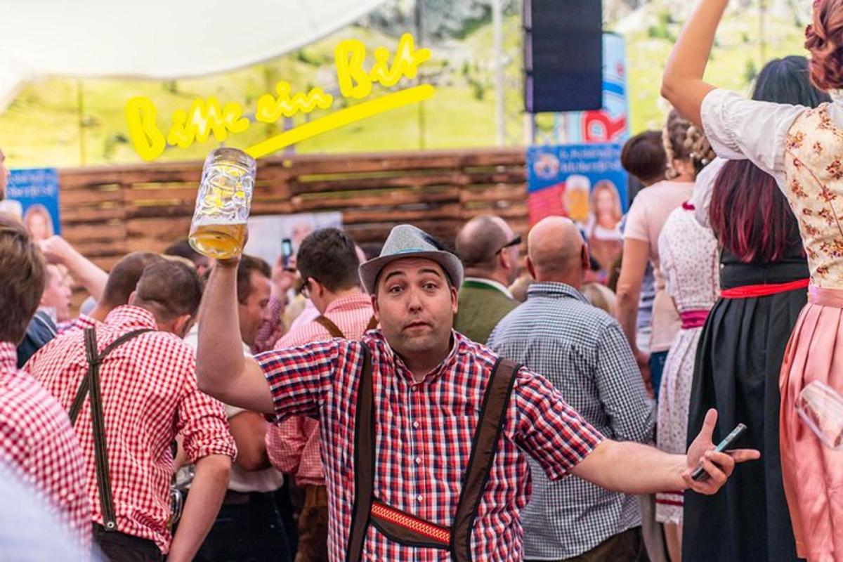 a man holding up a glass of beer in a crowd