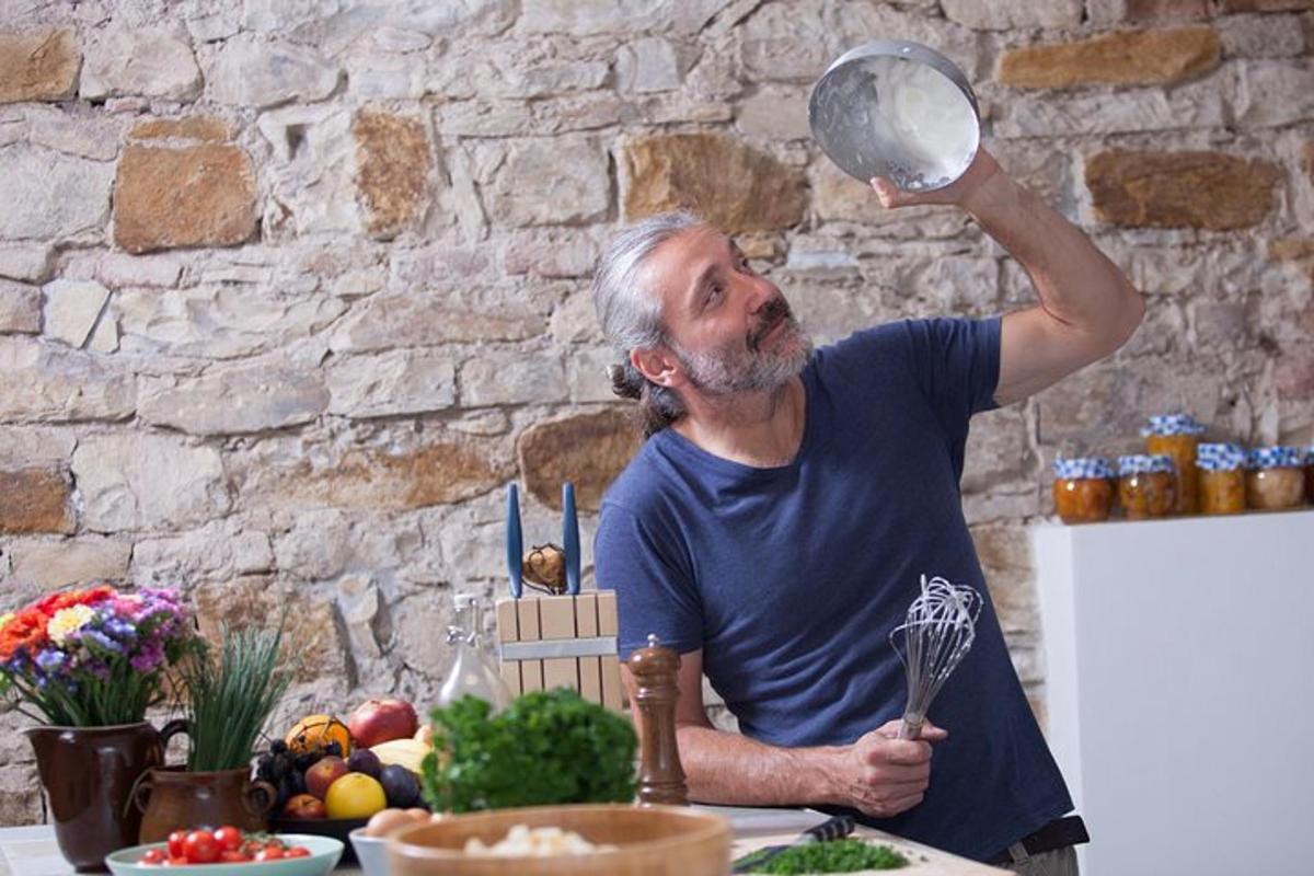 un uomo in piedi in cucina che regge una pentola