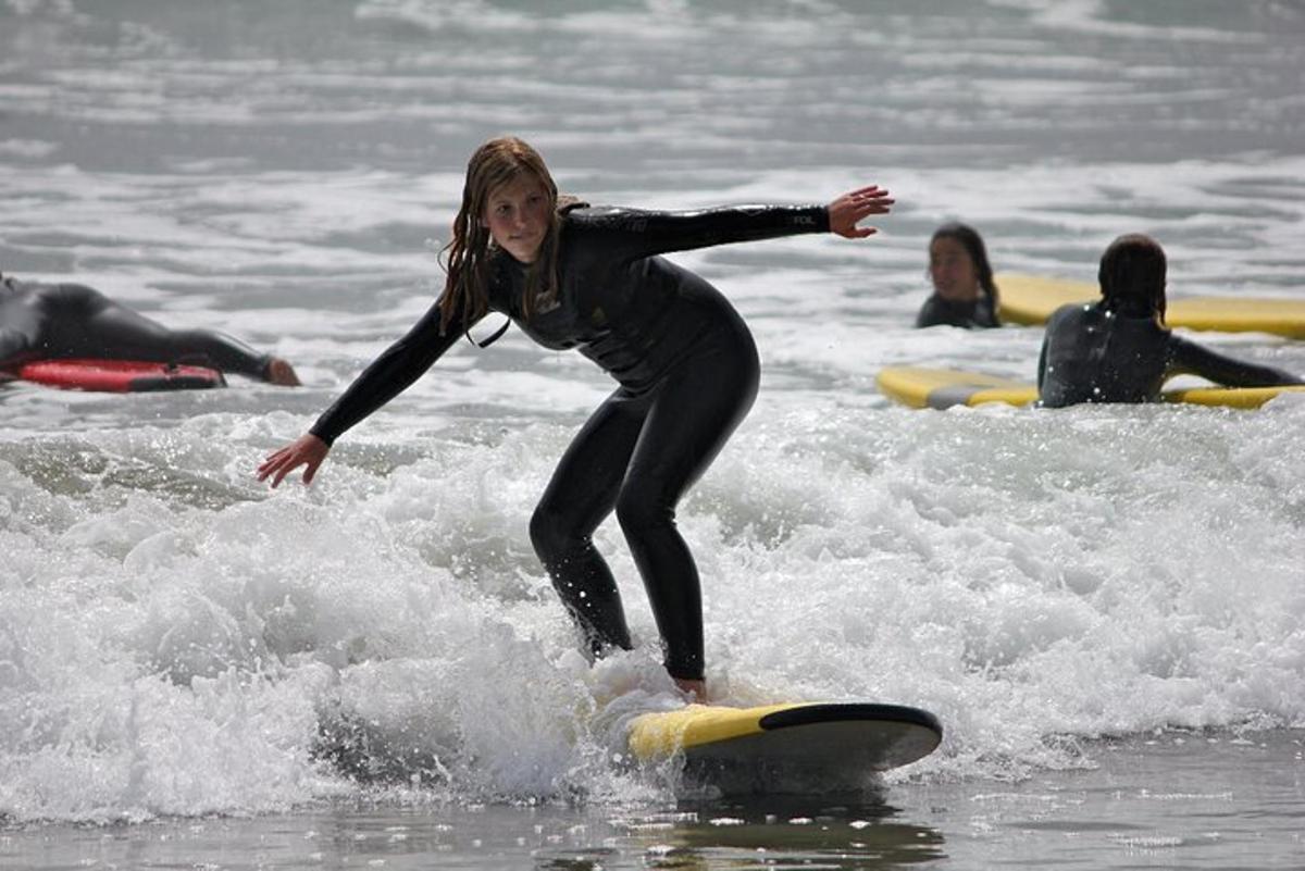 una giovane ragazza che cavalca un'onda su una tavola da surf nell'oceano