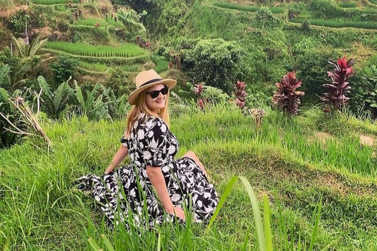 a woman in a hat sitting in the grass