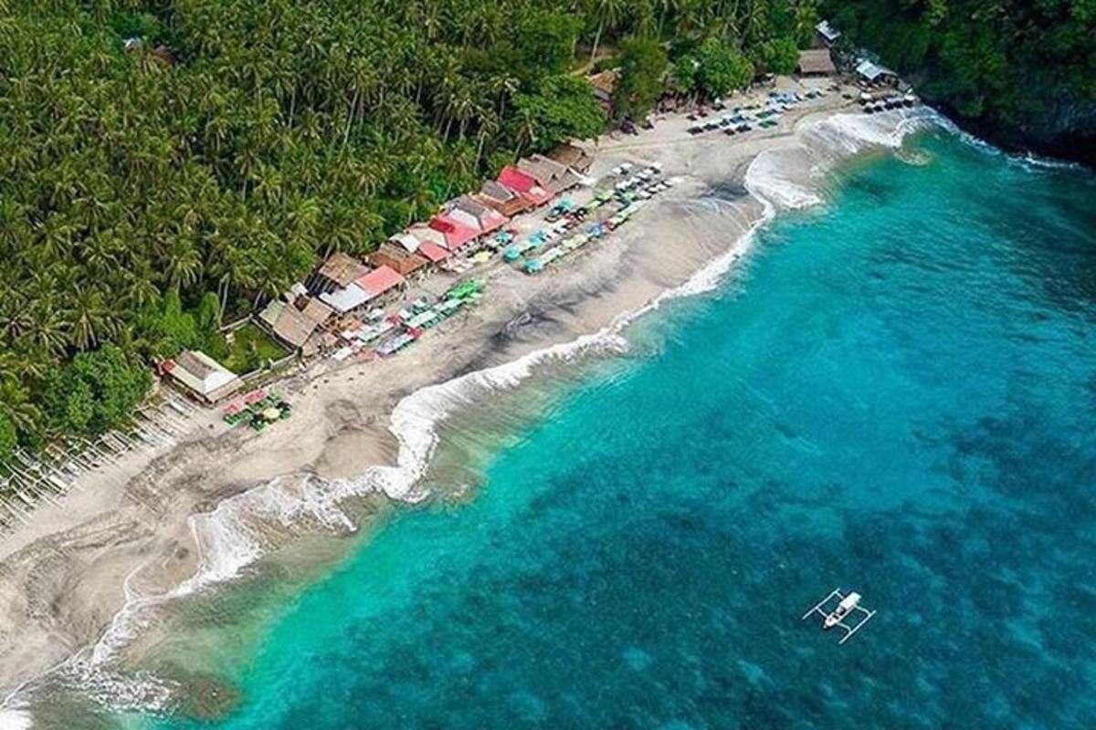 egy légi felvétel egy strandról, ahol üdülőhelyek csoportja található