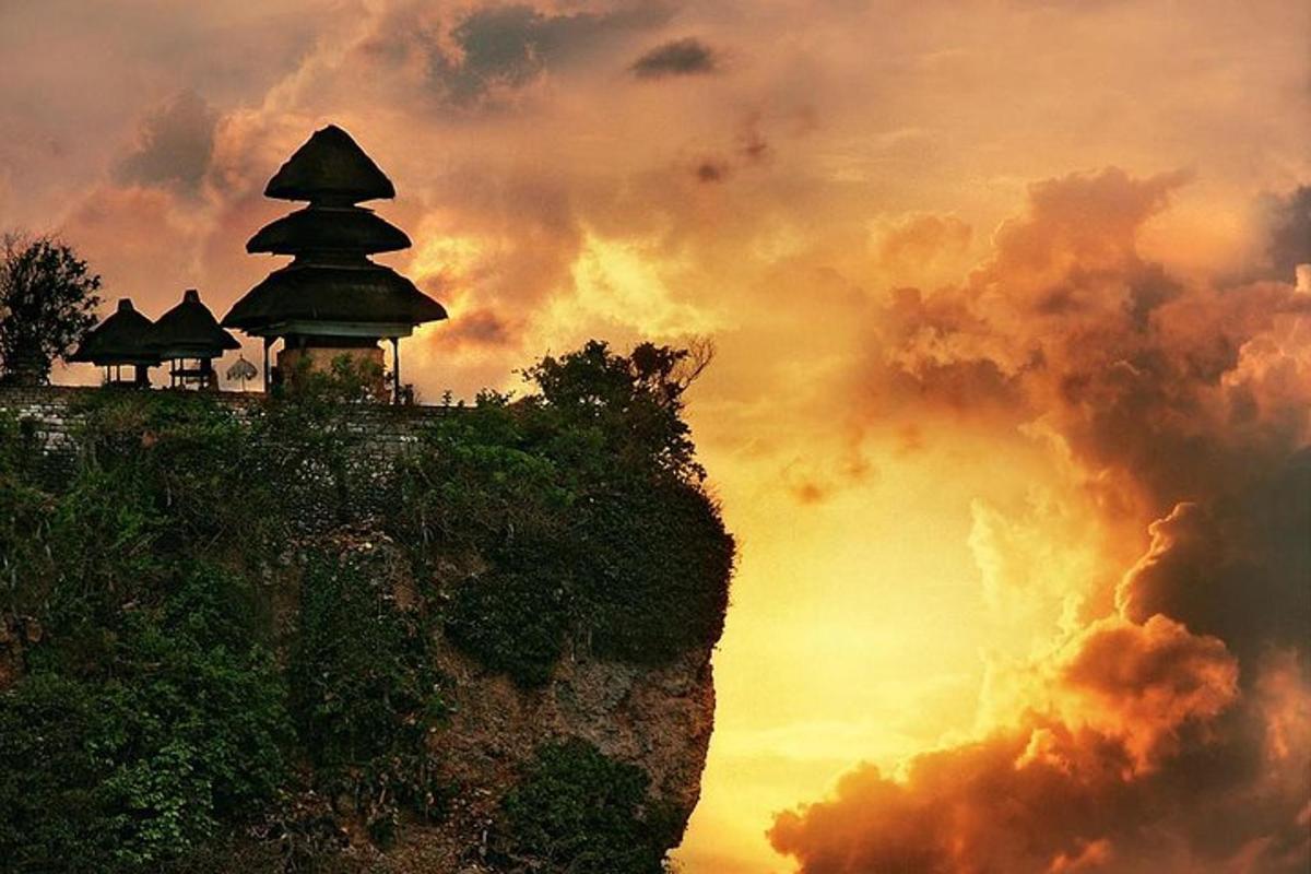 o pagodă pe vârful unui munte cu un apus de soare