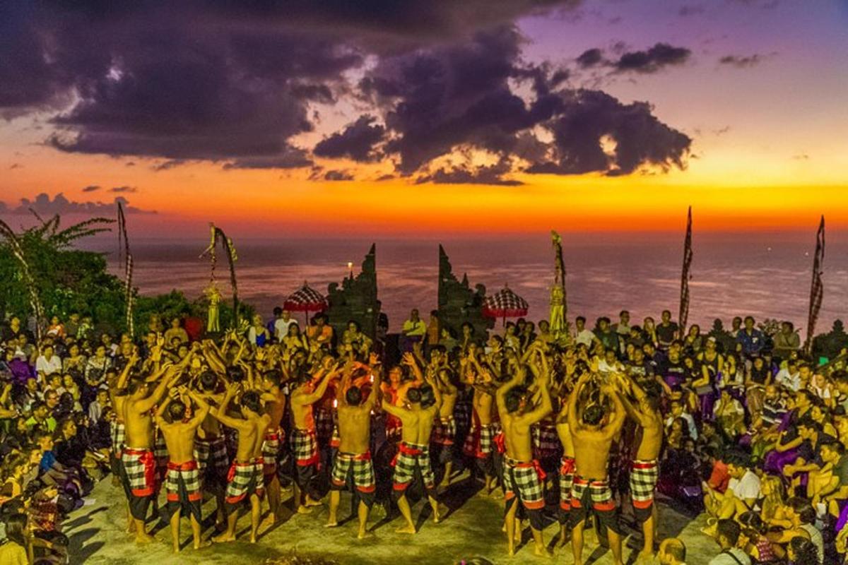 un grup mare de oameni dansând în fața unui apus de soare