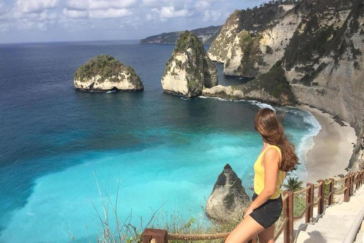 žena stojící na římse a dívající se na oceán