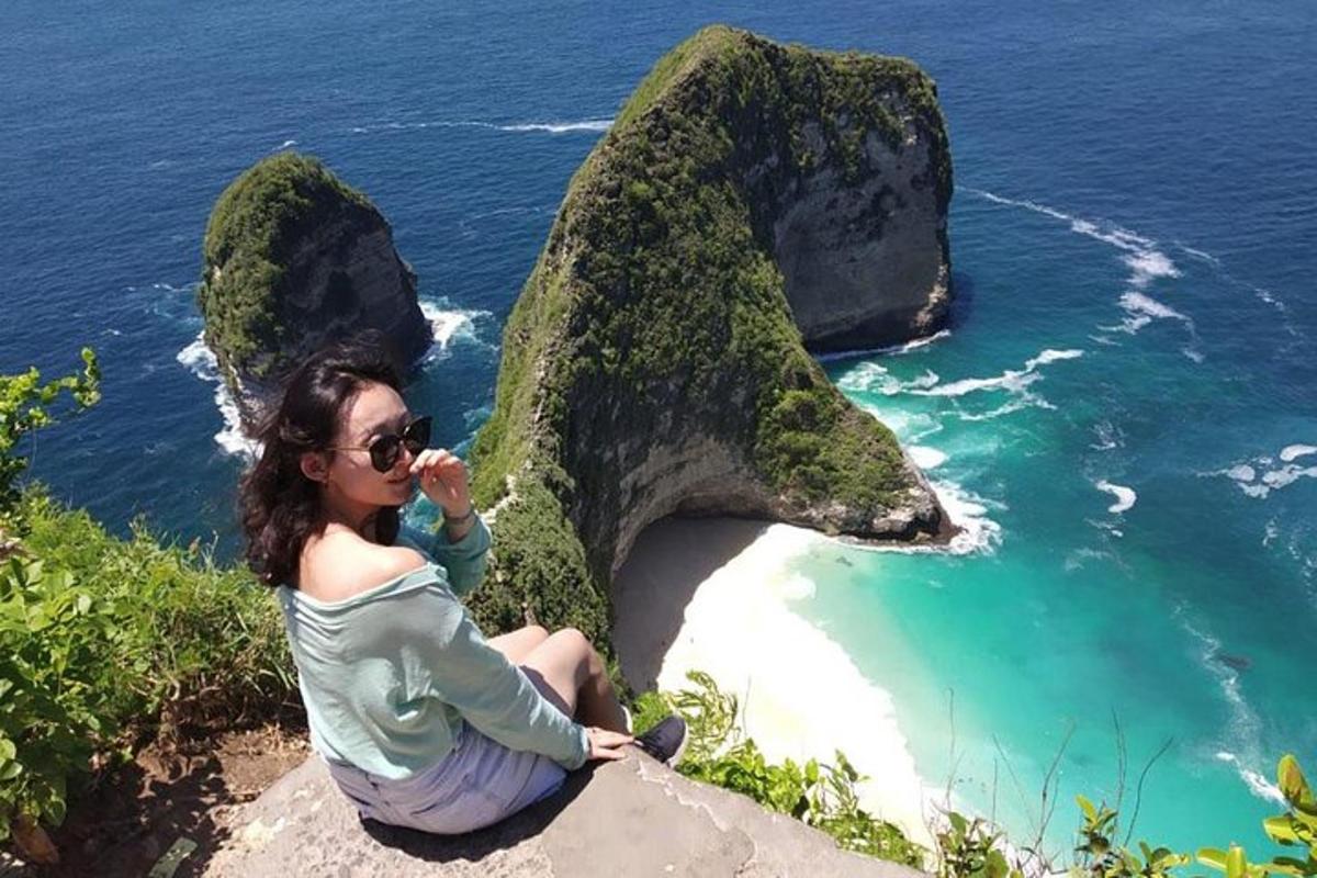 žena sedící na skále poblíž oceánu