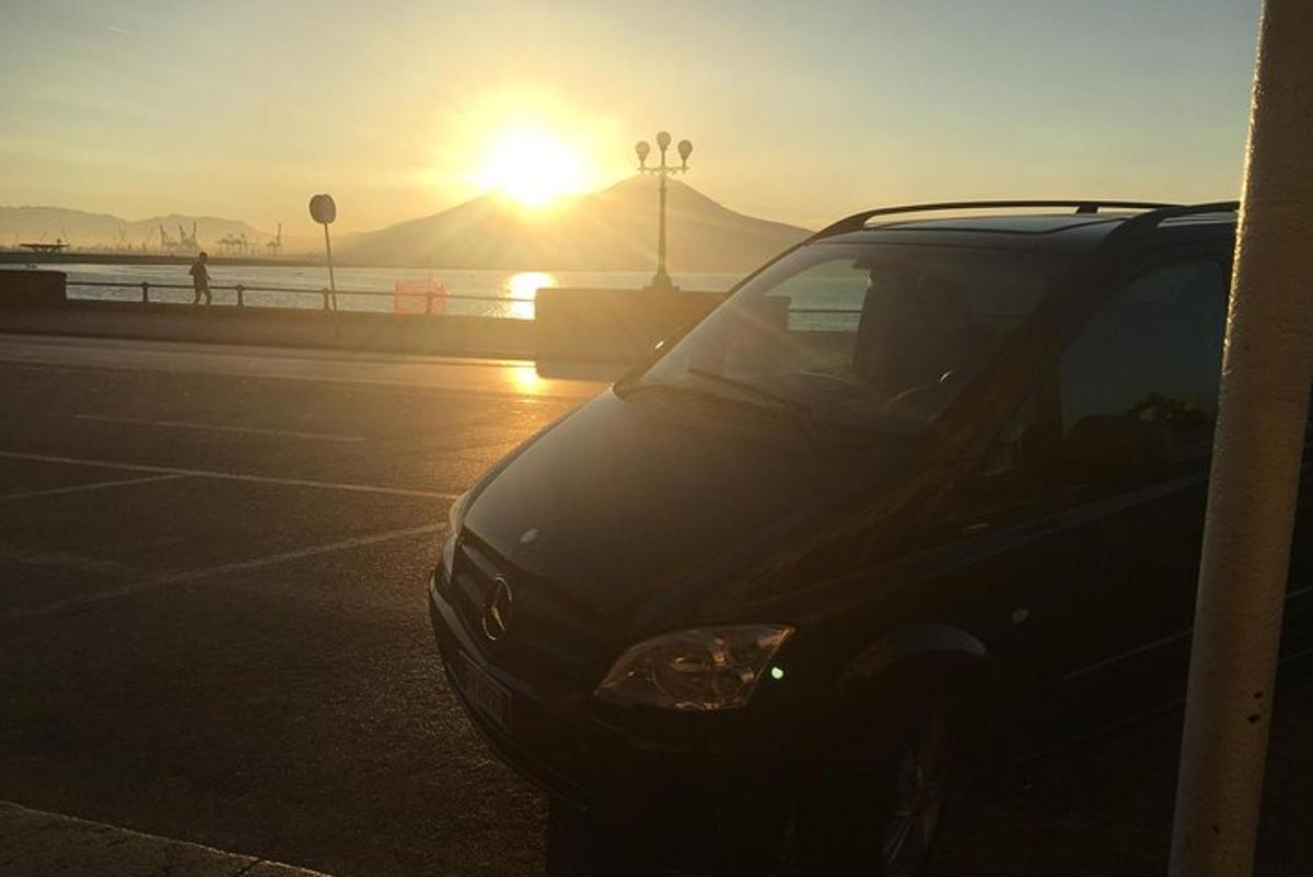 auto zaparkované na parkovišti se západem slunce v pozadí