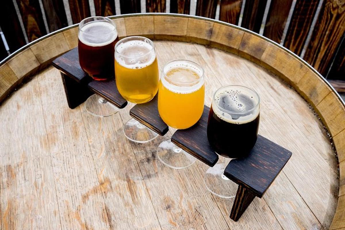 a group of four glasses of beer on a wooden table
