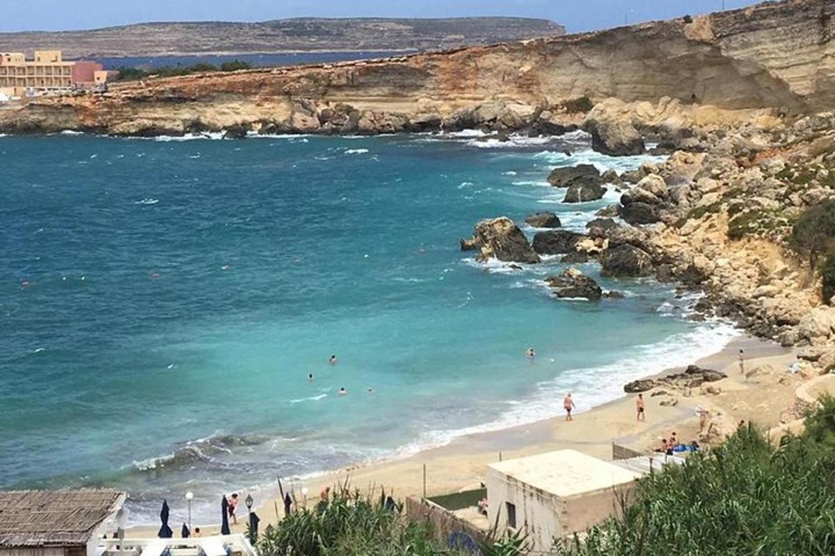a beach with people swimming in the water