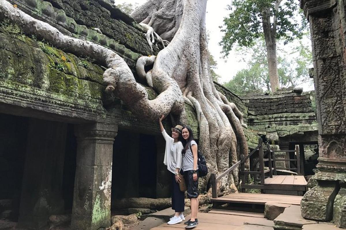 hai người phụ nữ đứng trước một cái cây trên một tòa nhà