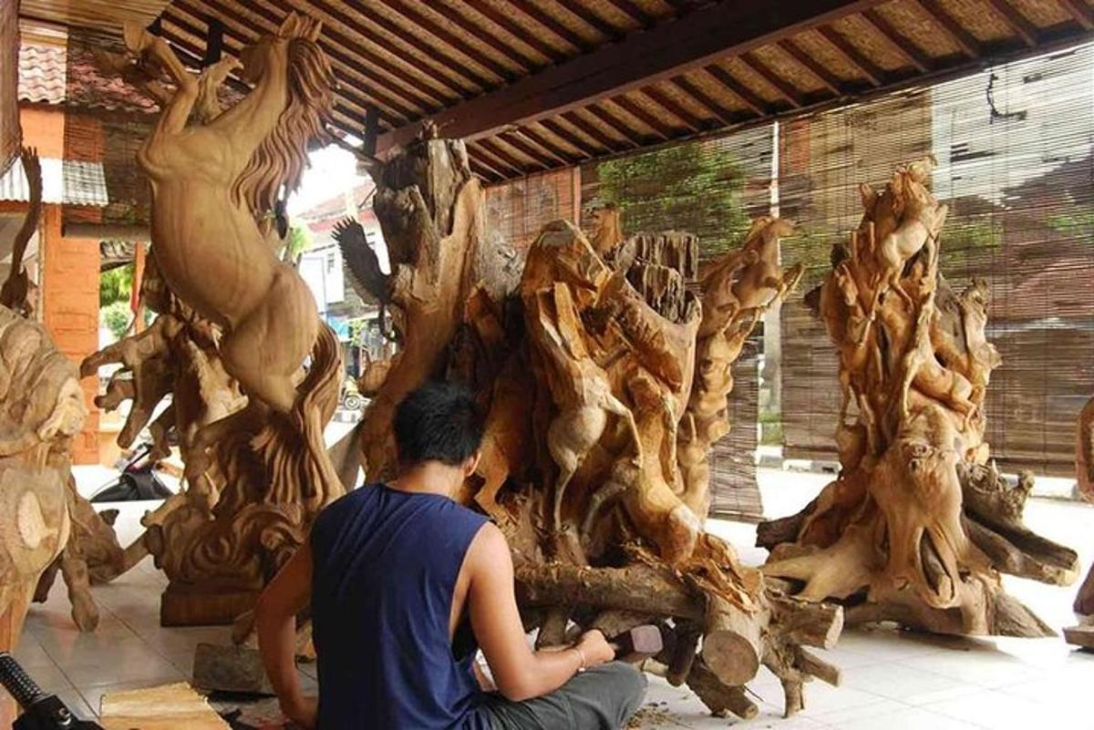 a man sitting on the ground next to a pile of wood
