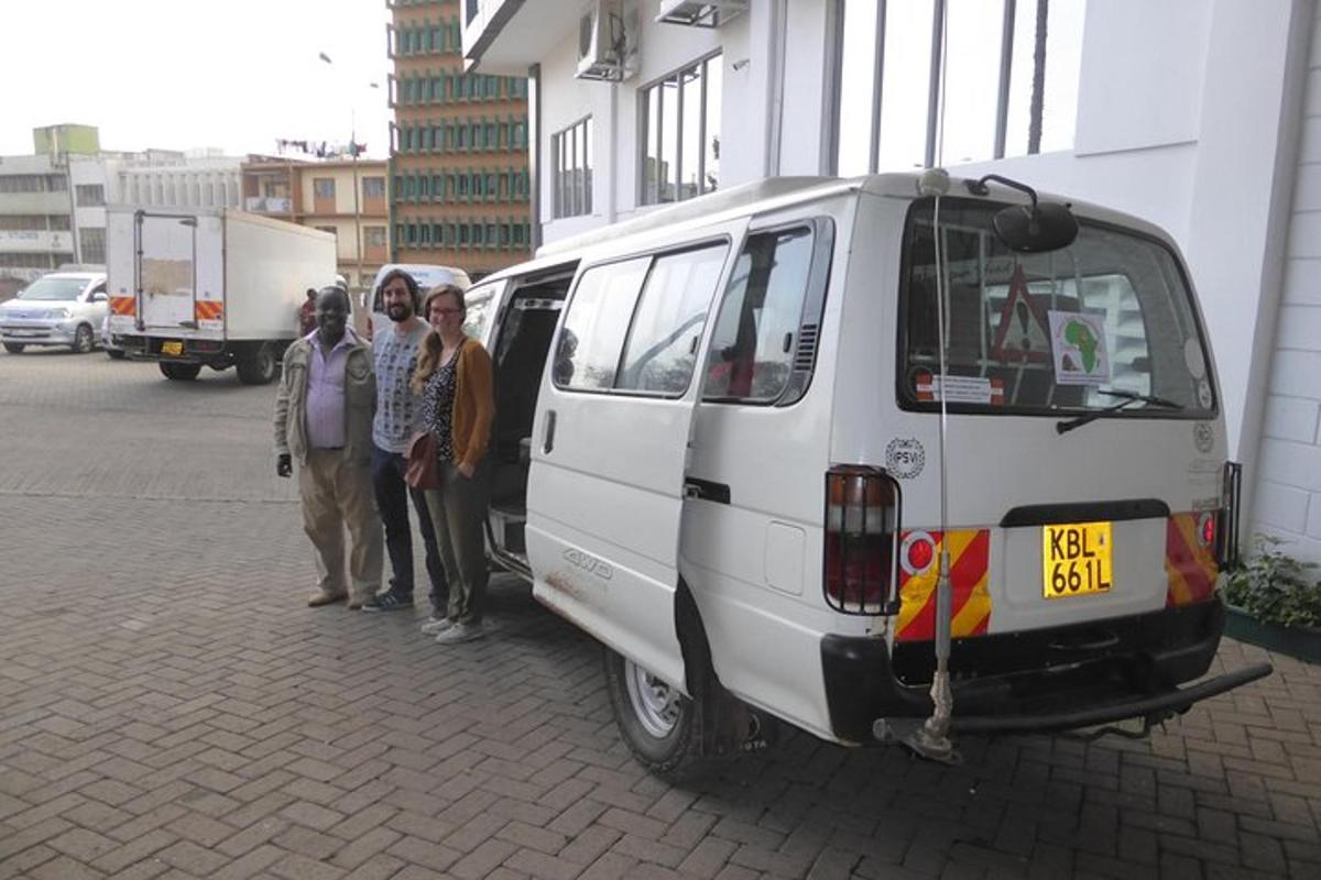 Un grupo de personas de pie junto a una camioneta blanca.