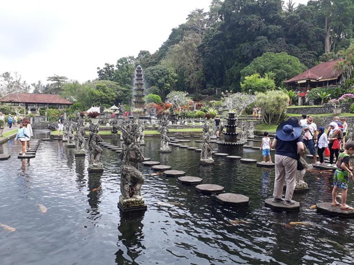 isang grupo ng mga tao na nakatayo sa paligid ng isang fountain sa tubig