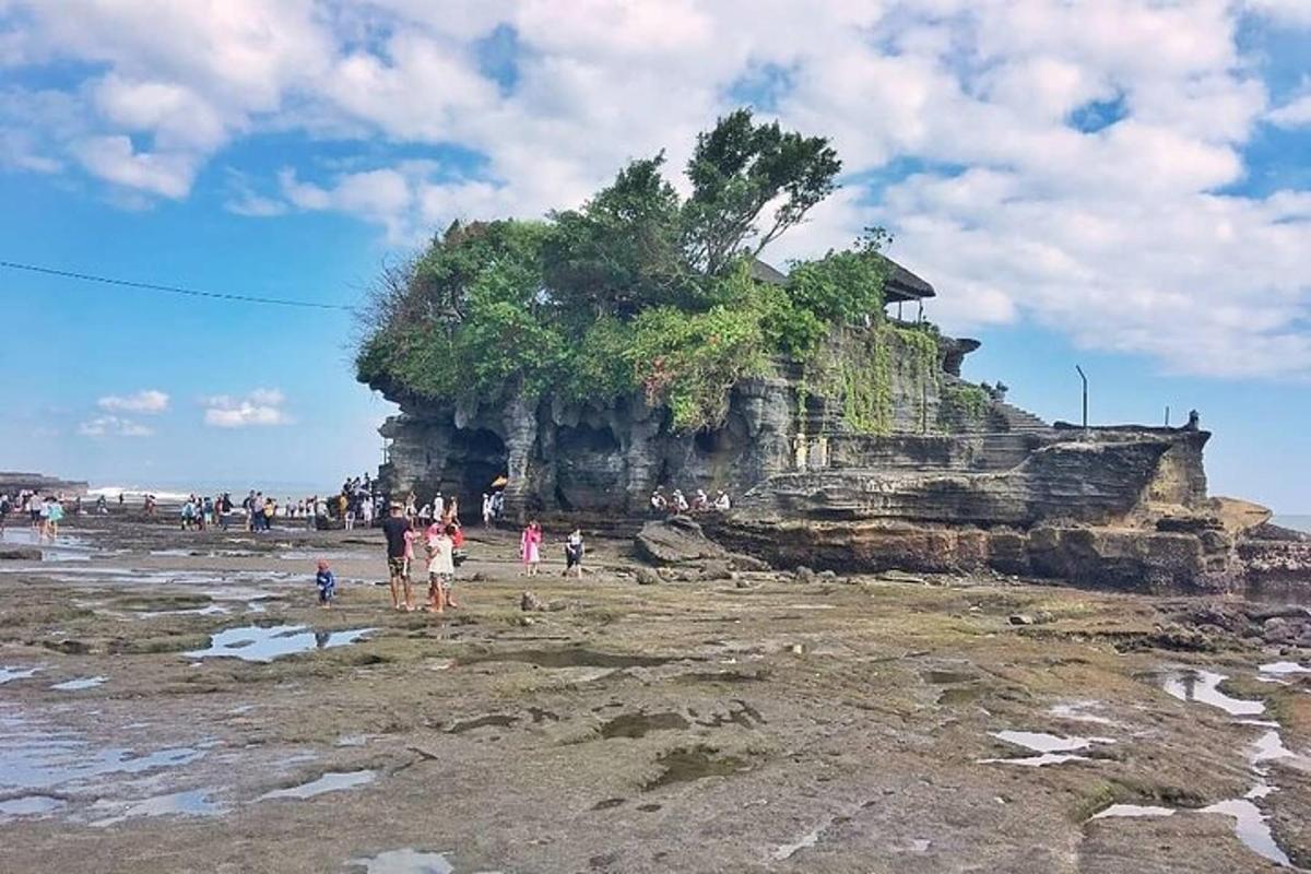 eine Gruppe von Menschen steht am Strand in der Nähe einer Insel