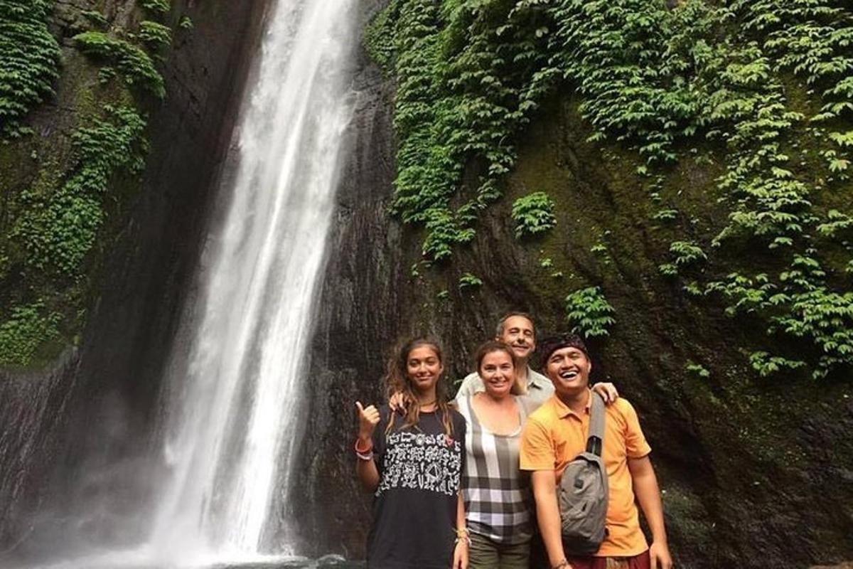 eine Gruppe von Menschen steht vor einem Wasserfall