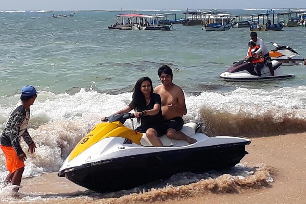seorang lelaki dan wanita duduk di atas jet ski di pantai