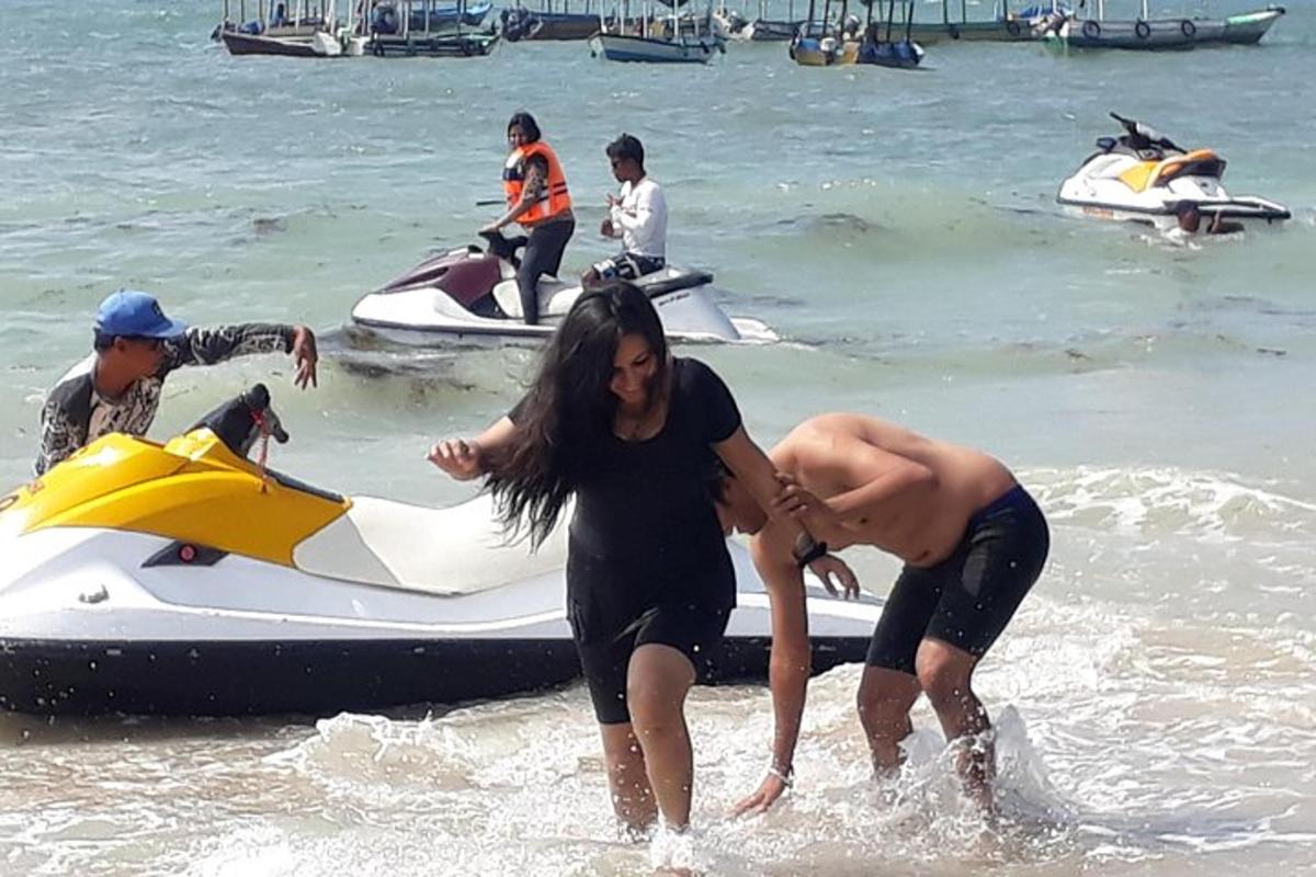 dua orang di dalam air di sebelah jet ski
