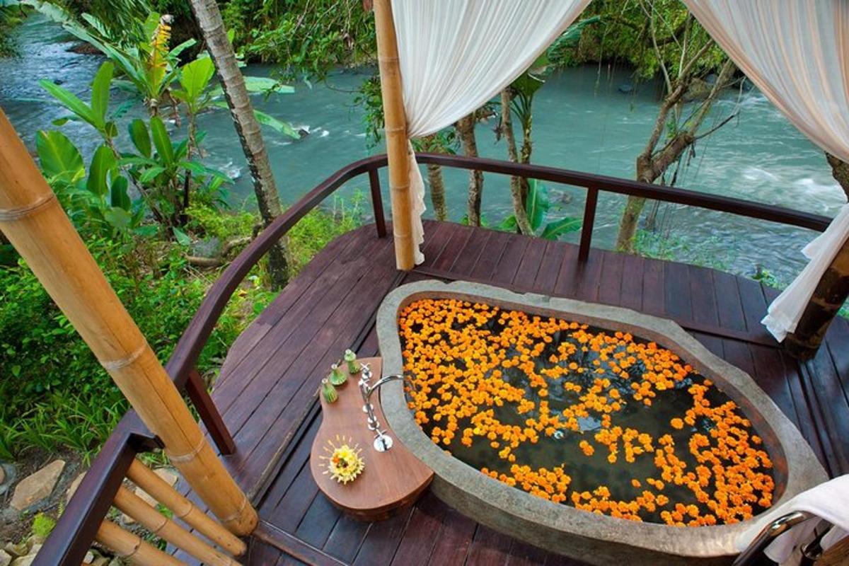 a bath tub filled with flowers on a wooden deck