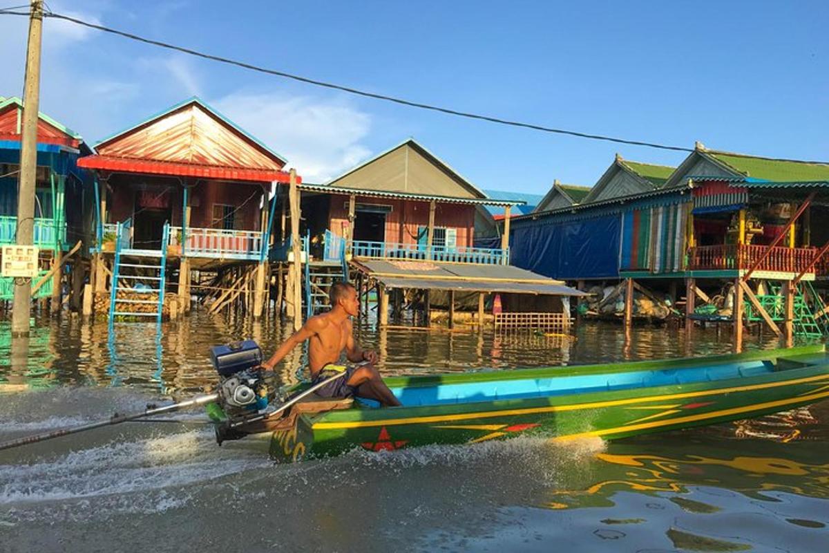 Un hombre en un barco en el agua con casas.