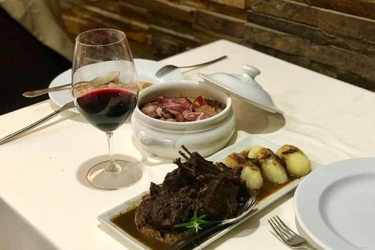 stůl s talířem jídla a sklenkou vína