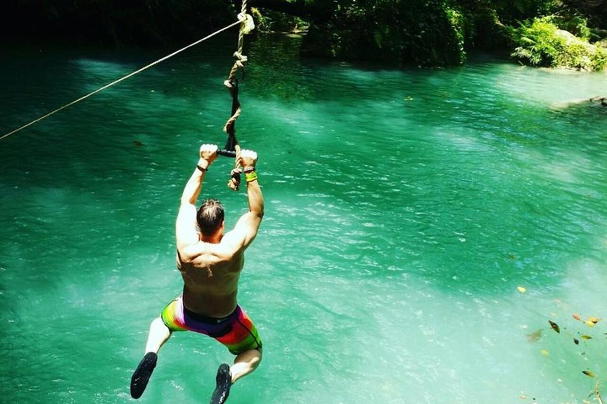 a man hanging from a rope in the water