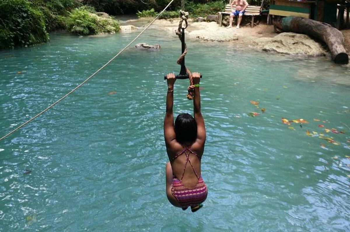 a person in the water on a rope in a river